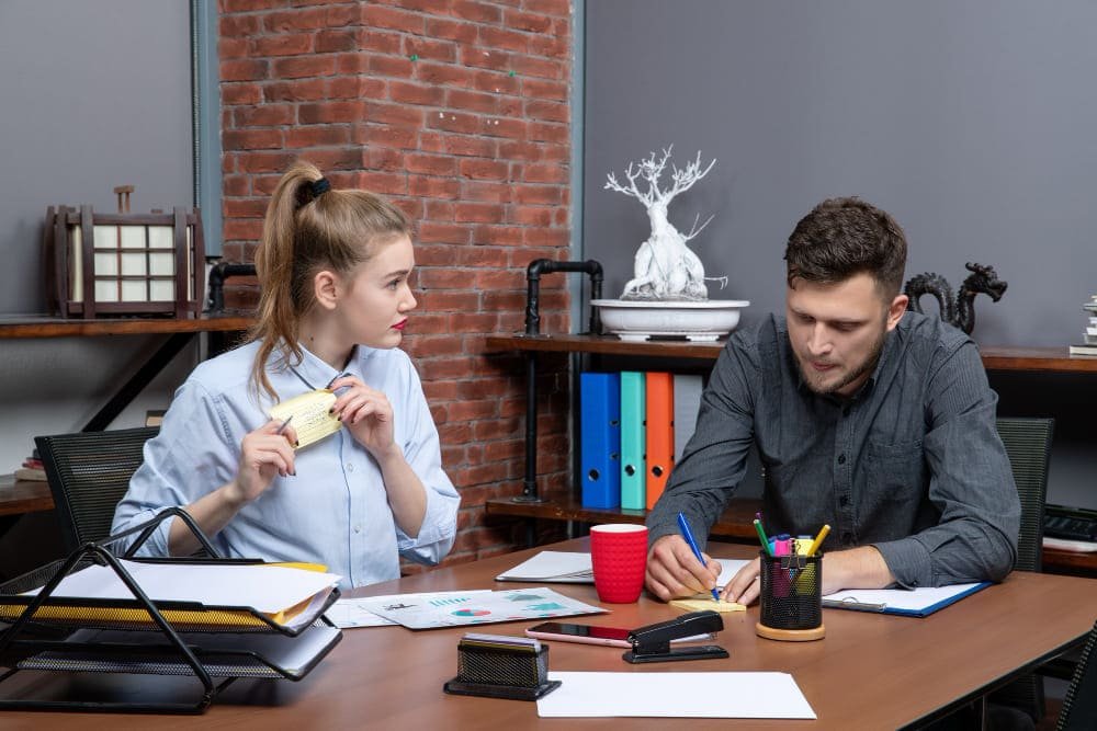 Top view of young funny office team focused on one issue in office